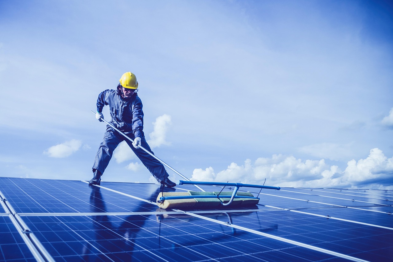 Monteur aan het werk op een dak vol zonnepanelen